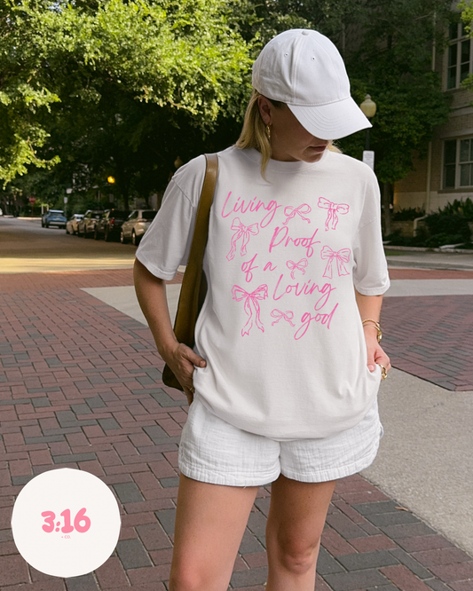 Living Proof of a Loving God – White Bow Script Tee
